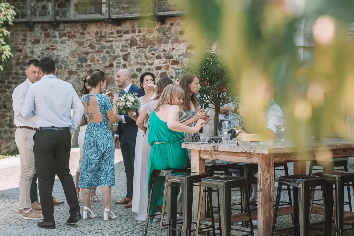 Mladoporočenca na Ljubljanskem gradu v Ljubljani; intimen trenutek ob grajskem obzidju v dokumentarnem poročnem slogu s pogledom na mesto.